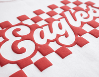 Red puff vinyl text 'Eagles' with checkered pattern on white fabric